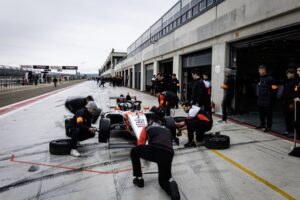 Equipo de mecánicos realizando una parada en boxes sobre pista mojada